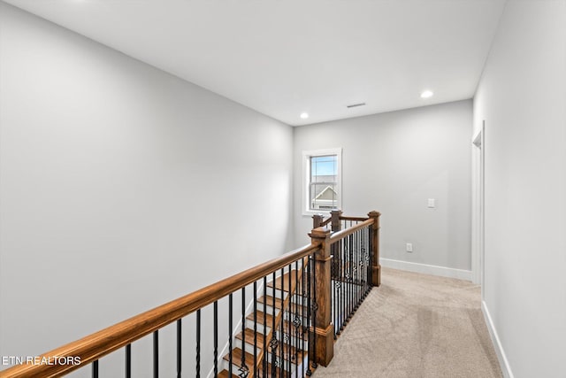 hallway featuring light colored carpet