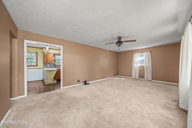 carpeted empty room with a textured ceiling and ceiling fan