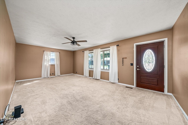 entrance foyer featuring a textured ceiling, ceiling fan, and a wealth of natural light