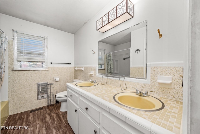 bathroom featuring toilet, tile walls, a shower with curtain, vanity, and hardwood / wood-style flooring