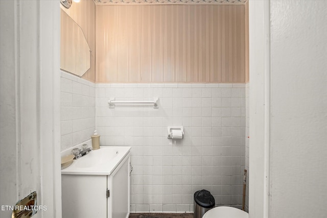 bathroom featuring tile walls, vanity, and toilet