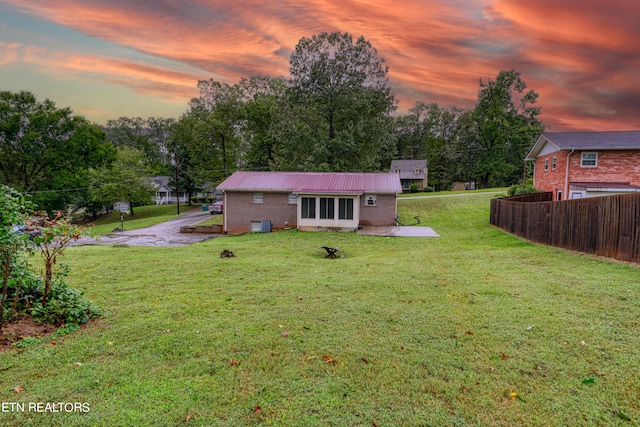 back house at dusk with a yard