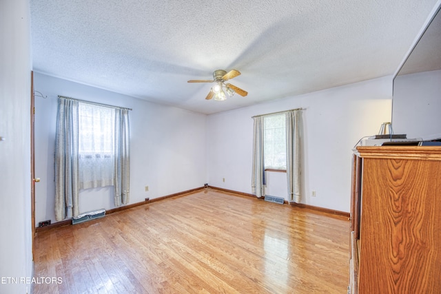 unfurnished bedroom featuring light hardwood / wood-style flooring, a textured ceiling, and ceiling fan