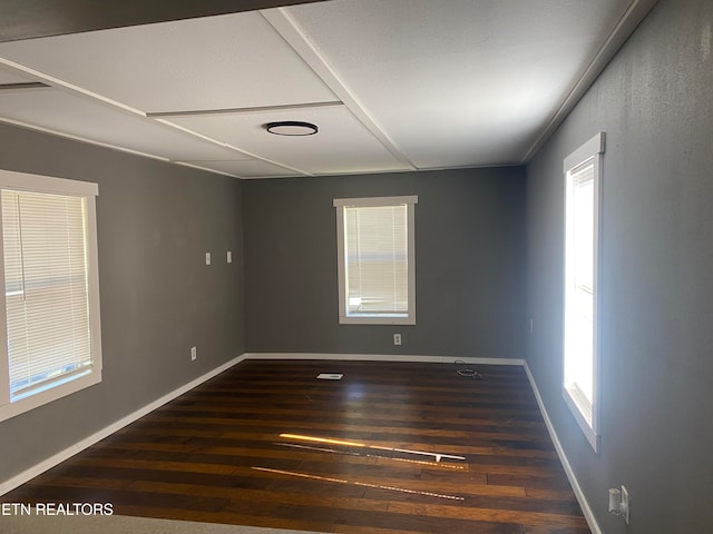 unfurnished room featuring dark hardwood / wood-style flooring and a wealth of natural light