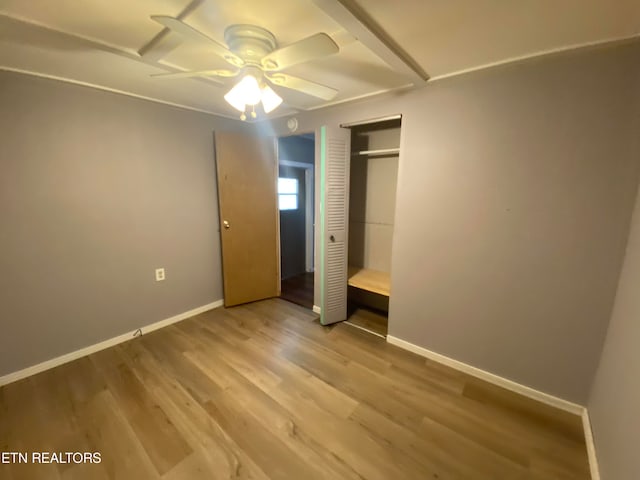 unfurnished bedroom featuring hardwood / wood-style flooring, ceiling fan, and a closet