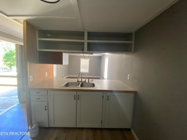 kitchen with dark hardwood / wood-style floors, sink, and white cabinetry