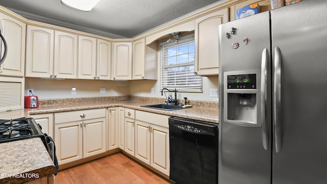 kitchen featuring sink, cream cabinets, stainless steel refrigerator with ice dispenser, black dishwasher, and light wood-type flooring