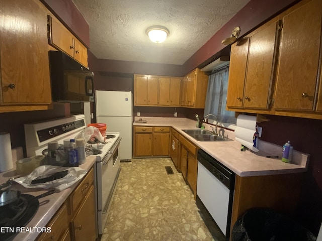 kitchen with white appliances, sink, and a textured ceiling