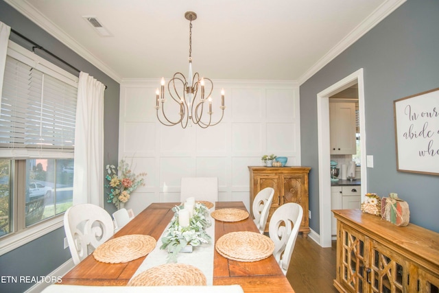 dining area with crown molding, dark wood-type flooring, and a chandelier