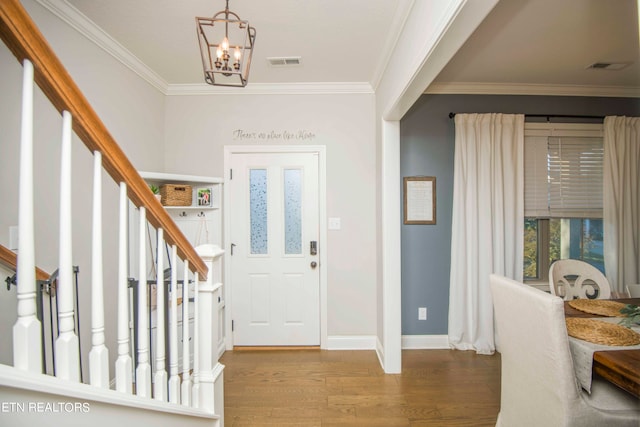 entrance foyer with hardwood / wood-style flooring, a chandelier, and ornamental molding