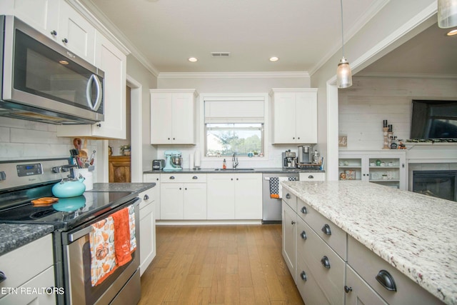 kitchen featuring light stone countertops, sink, stainless steel appliances, and white cabinets