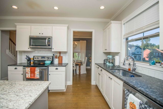 kitchen featuring dark wood-type flooring, sink, stainless steel appliances, backsplash, and white cabinets