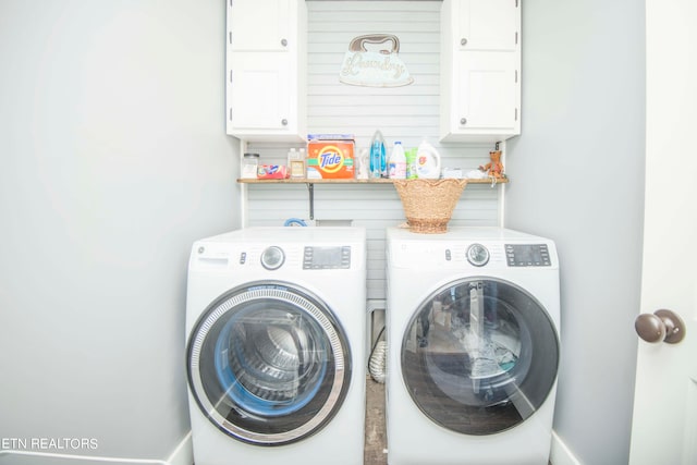 laundry area featuring separate washer and dryer and cabinets