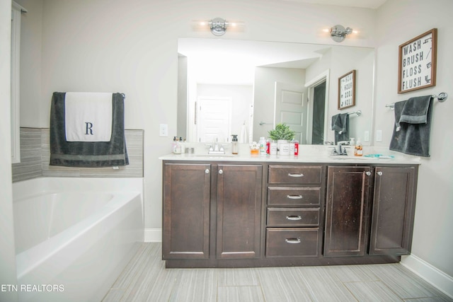 bathroom with a tub and vanity