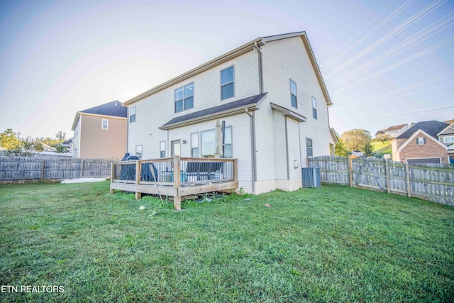 rear view of property featuring a deck and a lawn