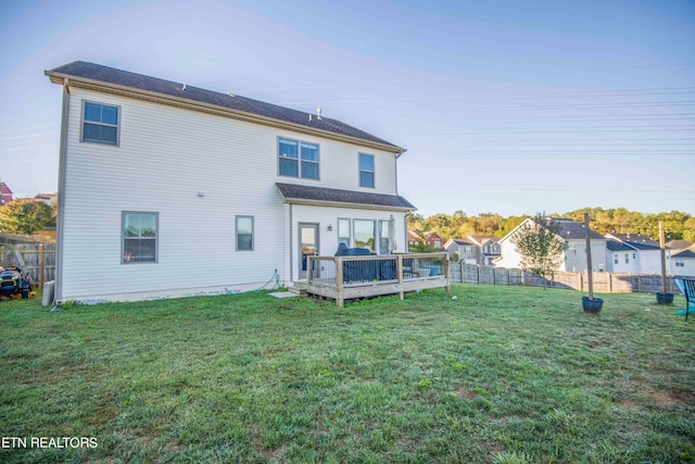 back of house featuring a yard and a wooden deck