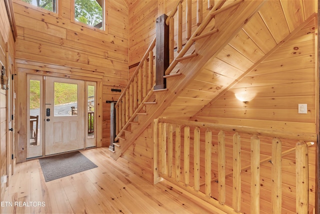 foyer with wood-type flooring, wooden walls, wood ceiling, and a wealth of natural light