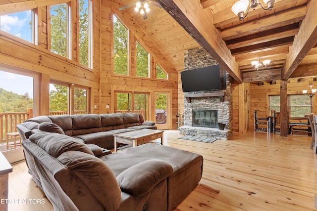 living room with high vaulted ceiling, beamed ceiling, light hardwood / wood-style floors, a chandelier, and wood walls