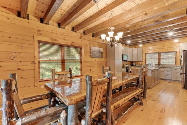 dining space featuring wooden walls and plenty of natural light