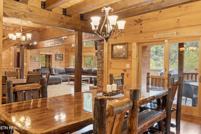 dining space with wood-type flooring, beam ceiling, and a healthy amount of sunlight