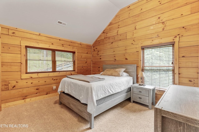 bedroom featuring wood walls, light colored carpet, and vaulted ceiling