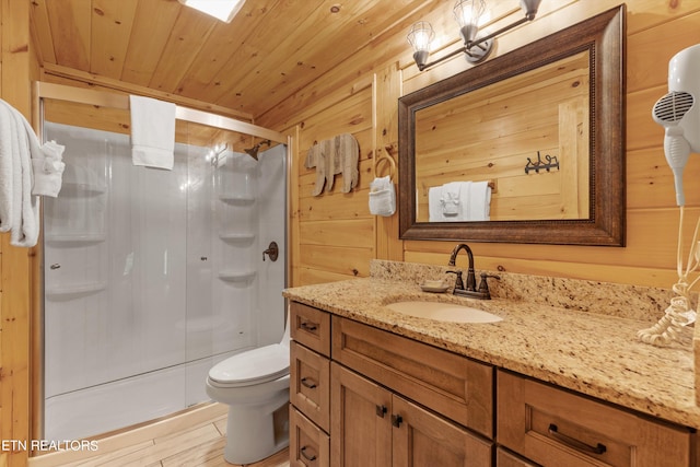 bathroom featuring toilet, wood-type flooring, an enclosed shower, wooden walls, and vanity