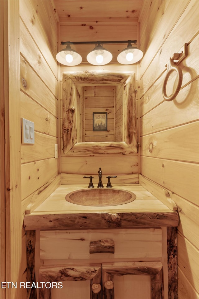 bathroom with vanity and wood walls