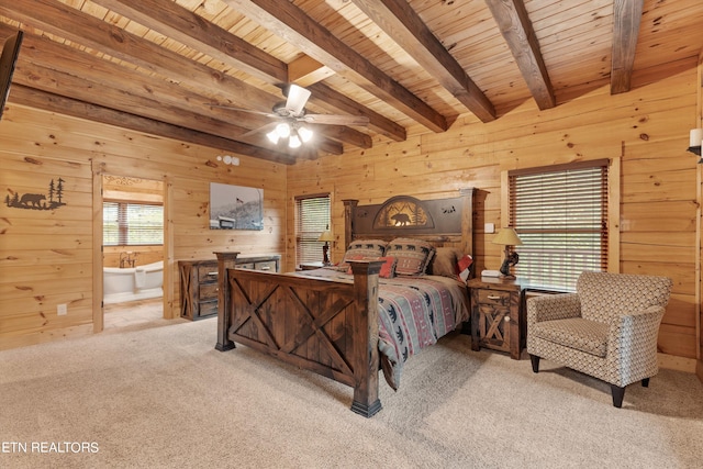 bedroom with light carpet, connected bathroom, wood walls, and beam ceiling