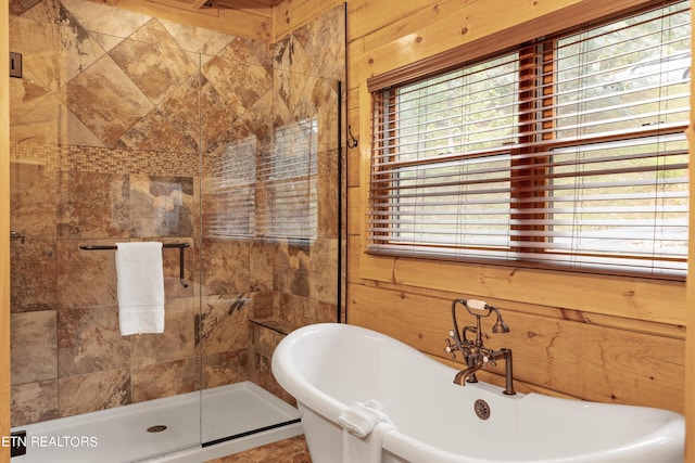 bathroom with wood walls and shower with separate bathtub