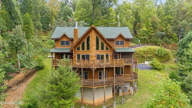 rear view of house featuring a yard and a deck