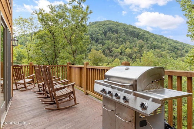 wooden deck with a mountain view and grilling area