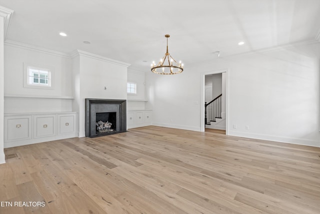 unfurnished living room featuring ornamental molding, a notable chandelier, and light wood-type flooring