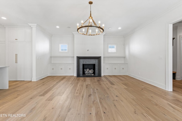 unfurnished living room featuring ornamental molding, light hardwood / wood-style flooring, a healthy amount of sunlight, and a notable chandelier