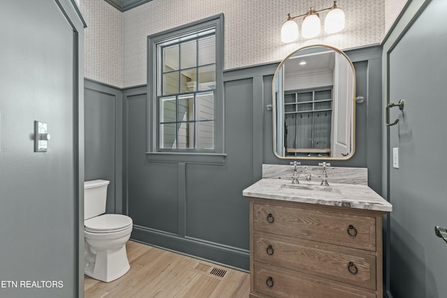 bathroom featuring hardwood / wood-style floors, vanity, toilet, and crown molding