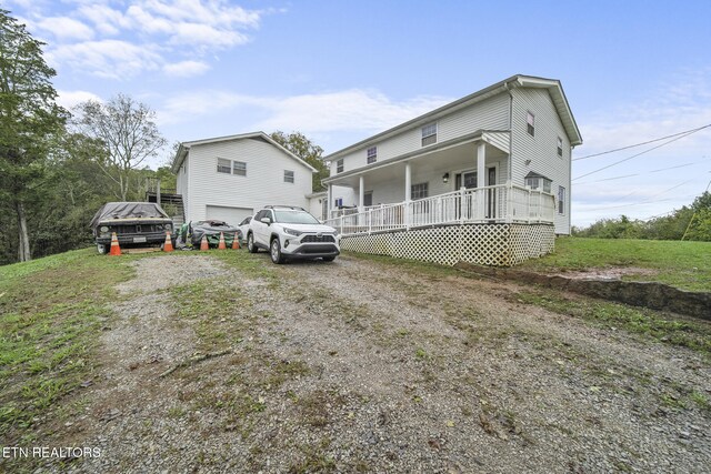 9832 Clift Rd, Strawberry Plains, TN 37871 - view of front facade featuring dirt driveway, covered porch, and a garage