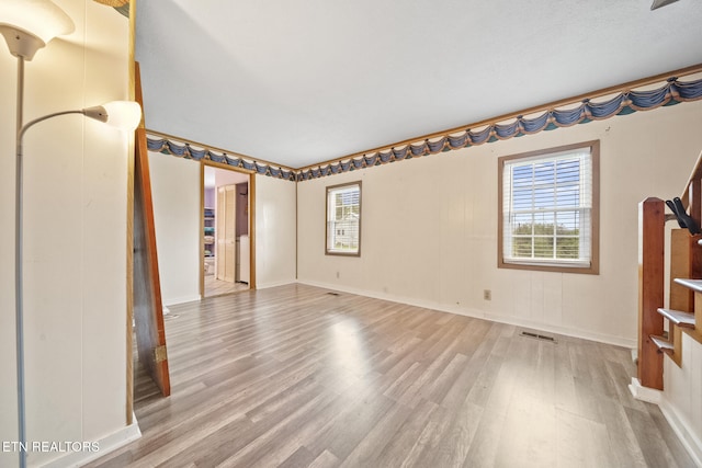 9832 Clift Rd, Strawberry Plains, TN 37871 - empty room with stairway, wood finished floors, visible vents, and plenty of natural light