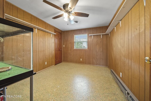 9832 Clift Rd, Strawberry Plains, TN 37871 - unfurnished bedroom with a ceiling fan, visible vents, a baseboard radiator, wooden walls, and baseboards