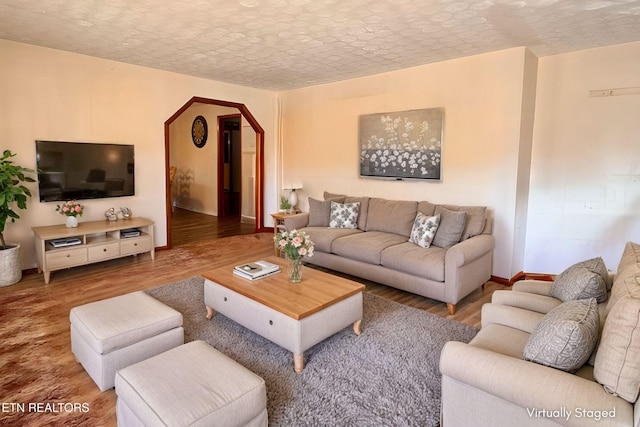 9832 Clift Rd, Strawberry Plains, TN 37871 - living area featuring baseboards, arched walkways, wood finished floors, and a textured ceiling