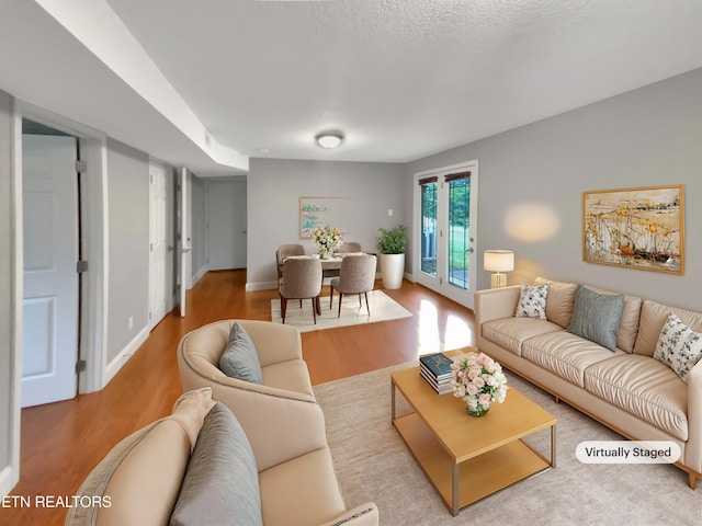 living room with light hardwood / wood-style floors and a textured ceiling