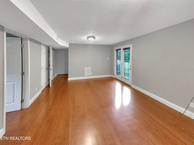 spare room with wood-type flooring and a textured ceiling