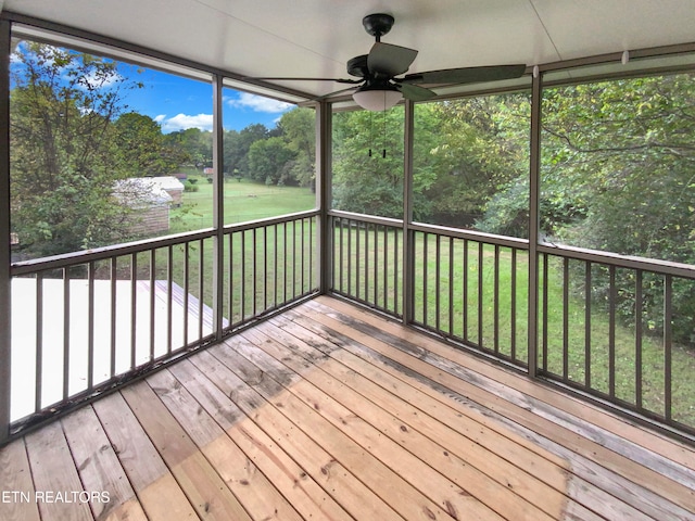 unfurnished sunroom featuring ceiling fan