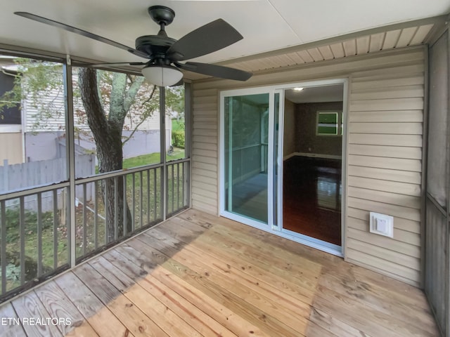 unfurnished sunroom with ceiling fan