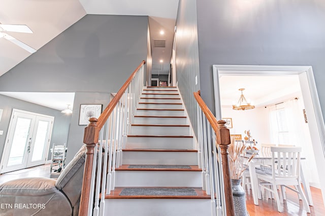 stairs featuring wood-type flooring, vaulted ceiling, french doors, and a wealth of natural light