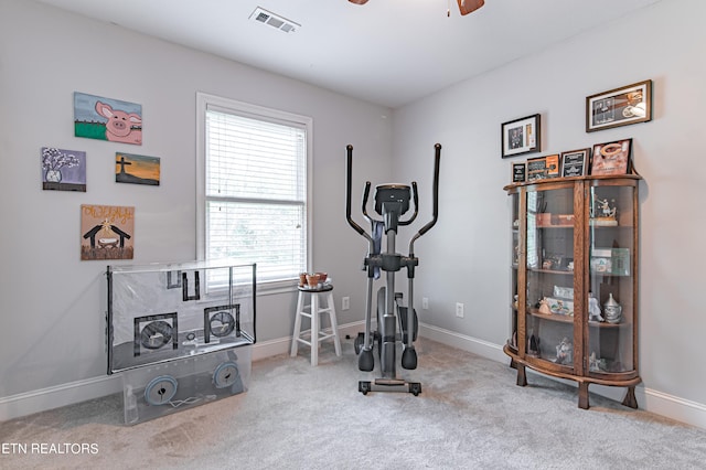 exercise area featuring light carpet and ceiling fan