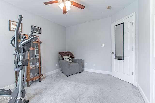 living area with light carpet and ceiling fan