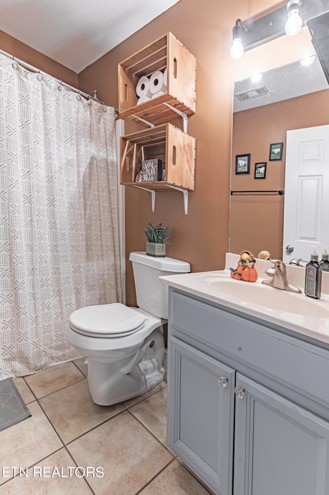 bathroom featuring tile patterned flooring, a textured ceiling, vanity, and toilet