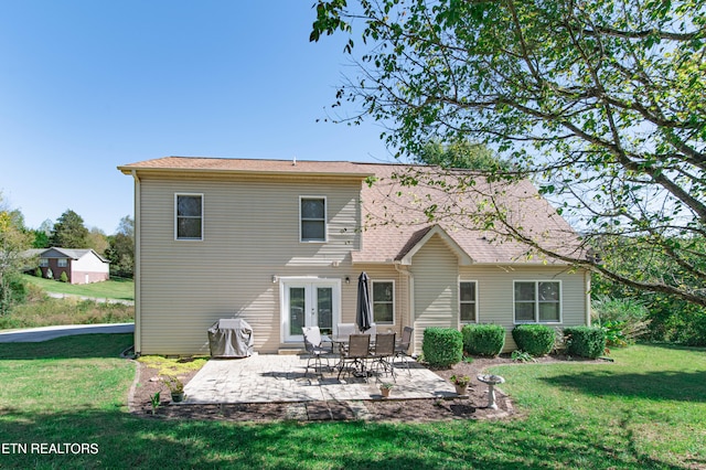 rear view of house with french doors, a yard, and a patio area