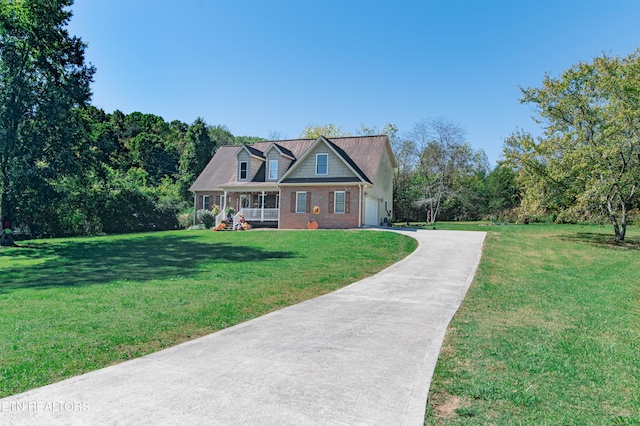 view of front of house with a front yard, a garage, and covered porch