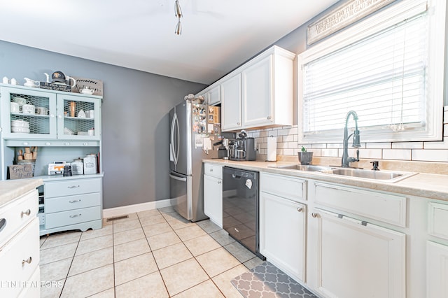 kitchen featuring stainless steel fridge, tasteful backsplash, black dishwasher, sink, and white cabinets