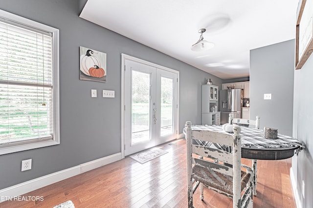 dining room with hardwood / wood-style floors and french doors